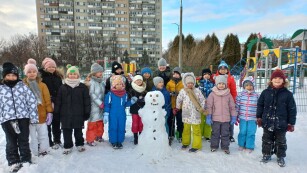 Uczniowie podczas zimowej zabawy na śniegu ze zrobionym bałwanem