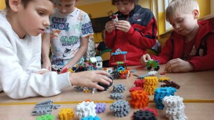 Czwórka chłopców buduje konstrukcje z klocków piankowych (wafli)