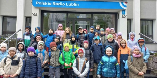 Dzieci stoją przed budynkiem radia. Za chwilę wejdą do środka budynku